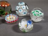 six glass marbles with different designs on them sitting on a table