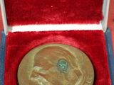 une médaille d'or dans une boîte rouge posée sur une surface rouge