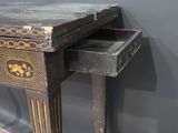 a small table with a drawer on it in front of a wall