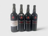 quatre bouteilles de vin sont alignées sur une surface blanche