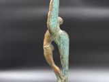 bronze sculpture of a woman holding a surfboard on a marble base