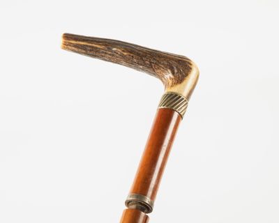 an old wooden walking stick with a metal handle on a white background