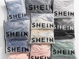 six bags filled with different types of shirts sitting on top of each other
