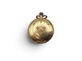 a close up of a gold pocket watch on a white surface