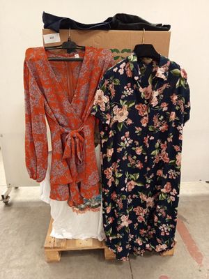 deux robes pour femmes suspendues à un portant devant un mur blanc