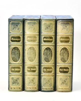 three old books sitting on top of each other on a white surface