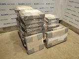 une pile de cartons posée sur une palette devant un mur