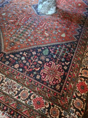 un vase de fleurs posé sur un tapis, à même le sol