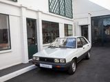a small white car parked in front of a building