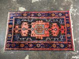 a blue and red rug on a concrete floor