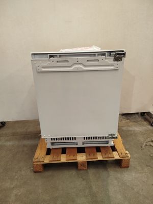 a white dishwasher sitting on a pallet in a room