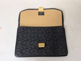 a close up of a black purse on a white surface