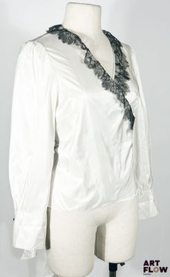 une photo d'un mannequin portant une chemise blanche bordée de dentelle noire