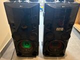 two speakers are sitting on a tiled floor in a room