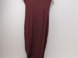 a maroon dress hanging on a hanger against a white wall