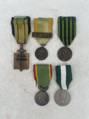 three medals and a medal are sitting on a white surface