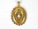 un gros plan d'un pendentif en or serti d'une perle