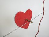 un objet rouge en forme de cœur attaché à une ficelle