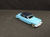a blue toy car with a black top on a table