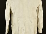 a white jacket on a mannequin stand against a black background