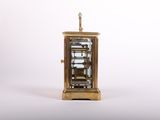 a small clock that is sitting on a white surface