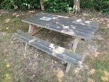 a picnic table with a sign on it in the grass