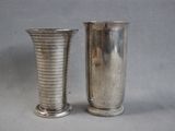 two silver vases sitting next to each other on a table