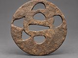 an iron disc with a stylized design in the center