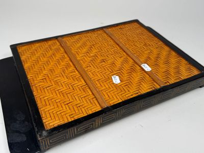 une boîte noire et orange avec un couvercle, posée sur une table blanche