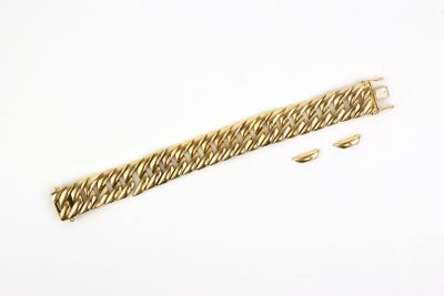 gros plan d'un bracelet en or sur une surface blanche