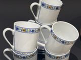 several cups and saucers are sitting on a table next to a plate