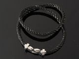 a black rope bracelet with a silver clasp on a black surface