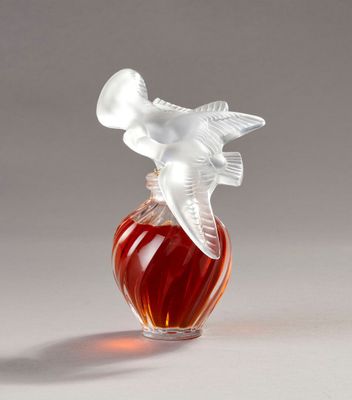 a glass bottle with a bird on top of it