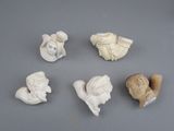 several small figurines of different shapes and sizes on a gray surface