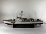 une maquette de bateau exposée dans une pièce blanche