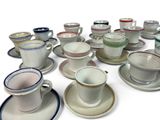 a lot of cups and saucers sitting on a table