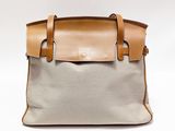 an image of a white and tan handbag with leather handles