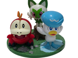 two figurines of pokemon and a cat on a table