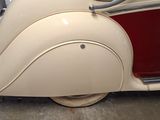 a white and red car parked inside of a garage