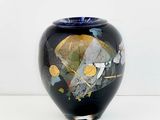 a black vase with a gold and blue design on it