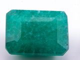 a close up of a green emerald stone on a white surface