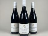 trois bouteilles de vin rouge posées côte à côte sur une table