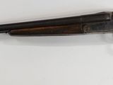 rifle mounted on the wall of a room with a white wall