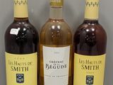 trois bouteilles de vin posées sur une table, l'une à côté de l'autre