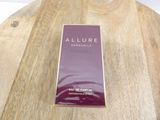 chanel allure eau de parfum spray bottle on a wooden table