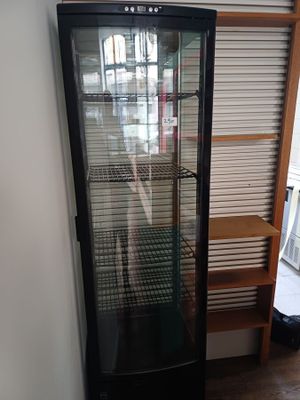 un réfrigérateur à porte vitrée dans un coin de la pièce