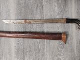 un couteau posé par terre à côté d'un autre couteau
