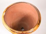 a brown vase that is sitting on a white surface