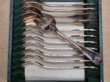 a set of silverware in a green case on a table