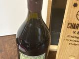 une bouteille de vin posée sur une table à côté d'une caisse en bois